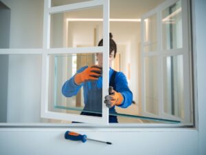 Fachowiec wymieniający szybę w ramie okna