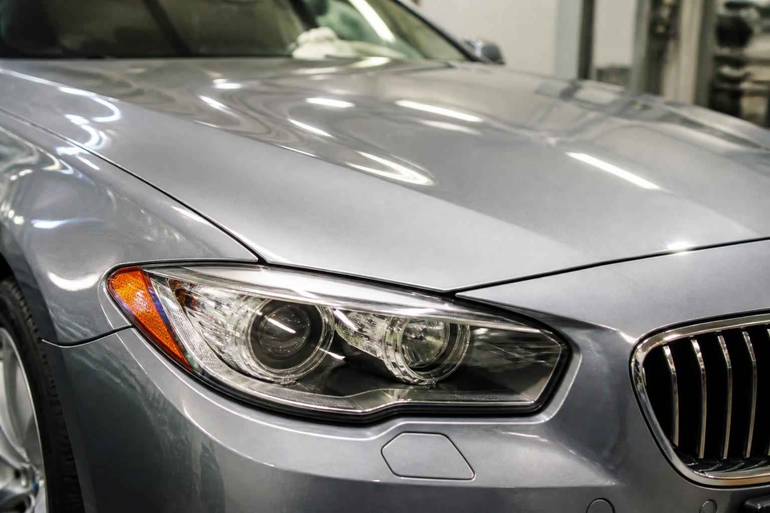 Zbliżenie na reflektor i przednią część srebrnego samochodu BMW